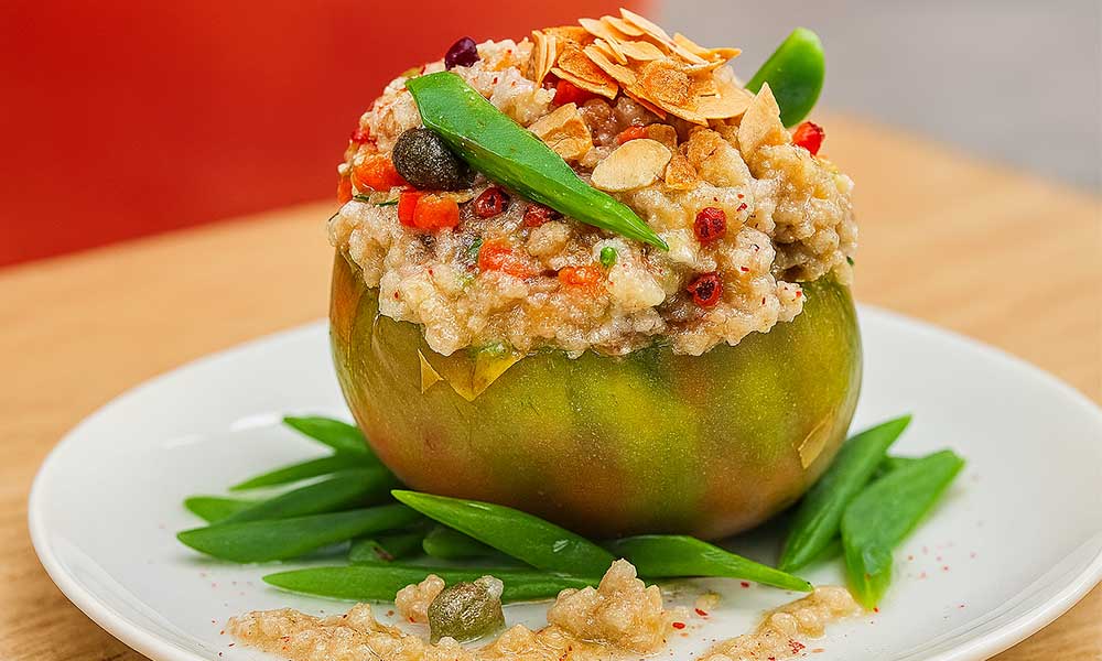Tomates Montserrat rellenos de cebada melosa, verduras y alga wakame, coronados con tofunesa y almendras tostadas. Un plato vegano, depurativo, relajante y lleno de energía.